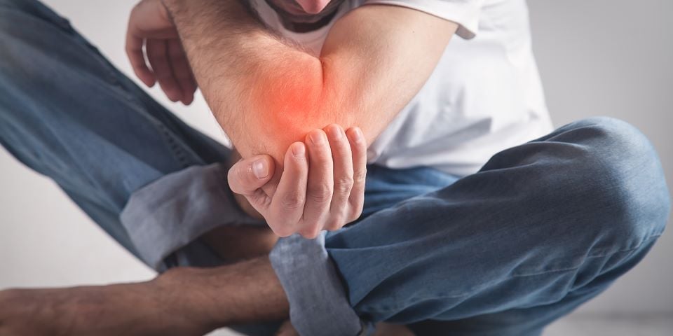 Homem com inflamação no cotovelo