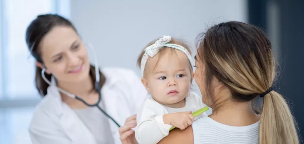 Médica avaliando criança com a mãe