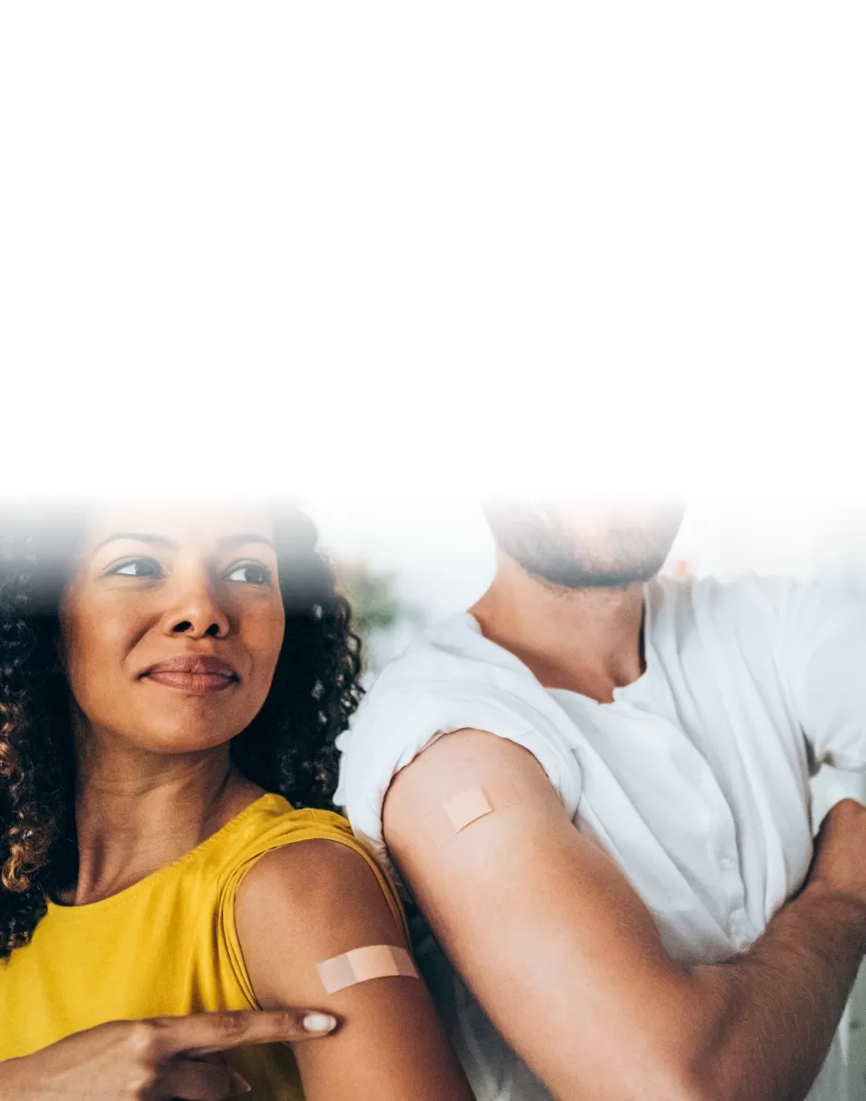 Homem e mulher mostram braço vacinado com curativo