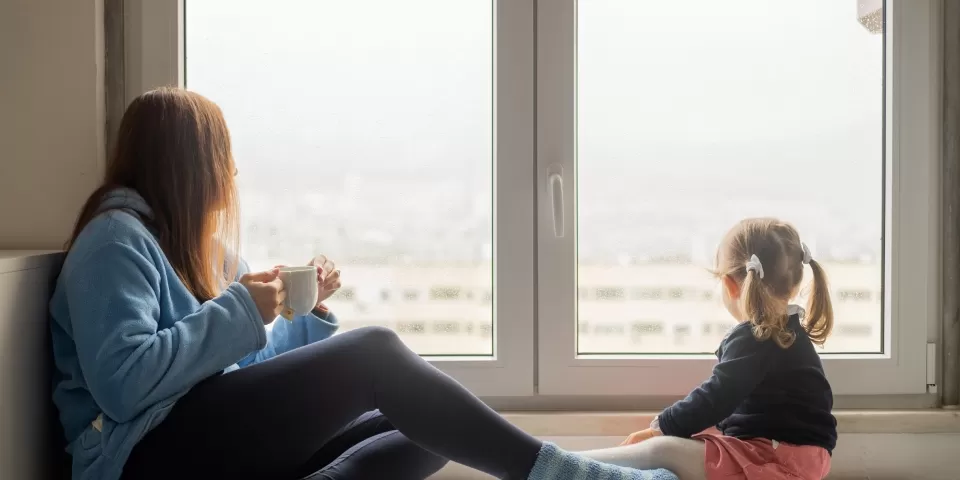 Mulher e criança sentadas na janela