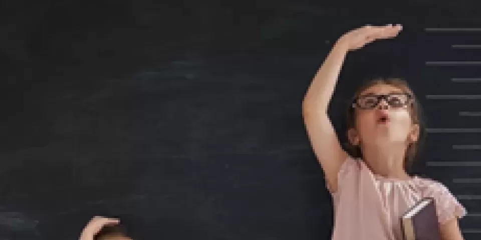 Imagem de duas crianças sendo medidas por régua na parede