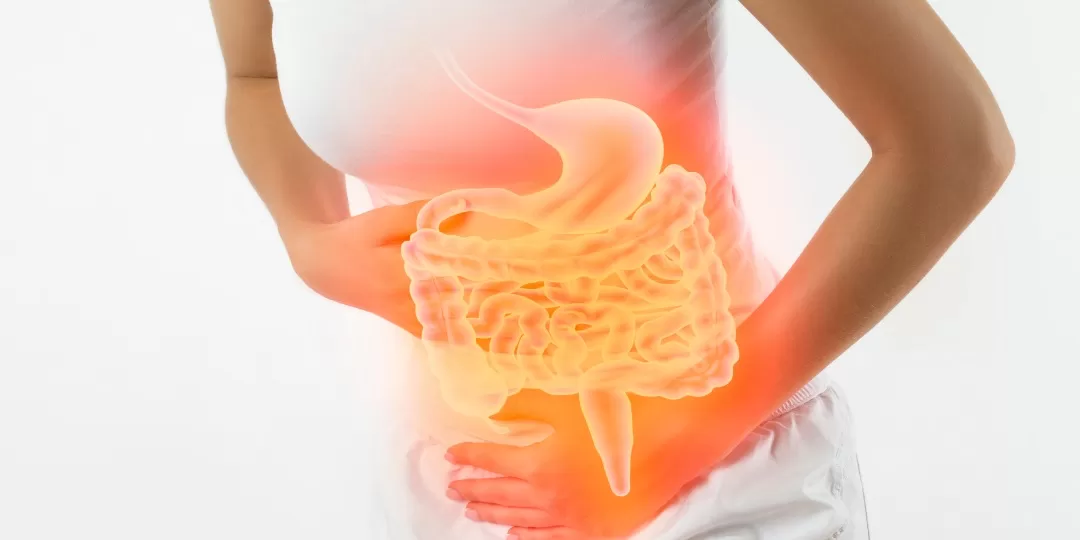 Mulher com as mãos na região gastrointestinal